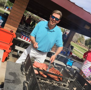 Photo of company president grilling during celebration of employee's U.S. citizenship. 