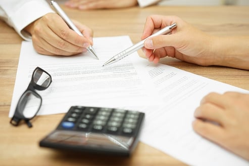 A photo of two people reviewing paperwork for a high deductible health plan.