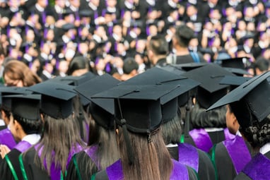 A photo of a graduating class listening to speakers during a commencement ceremony.