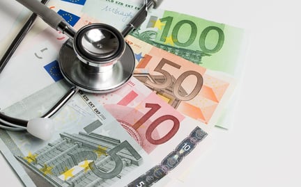 A photo of European currency with a doctor's stethoscope.