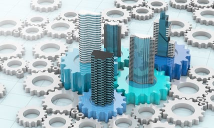 An image of a few blue gears with buildings on top surrounded by plain white gears with nothing on top.