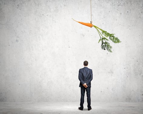 image of a business man facing a dangling carrot.