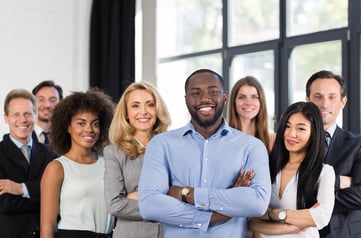 A photo of a diverse group of human resources personnel smiling at the camera.