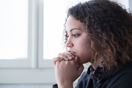 A photo of a woman staring into the distance, appearing to be lonely.