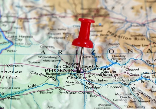 A photo of a map of Arizona with a pin sticking into the greater Phoenix region.
