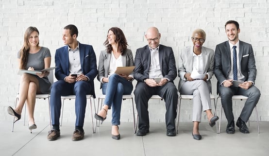 photograph of varied age and gender workforce sitting on chairs.