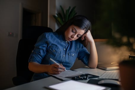 A photo of a woman working in her office, well into the evening hours.