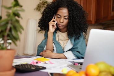 A photo of a woman on the phone, negotiating lower monthly payments on her medical bills.