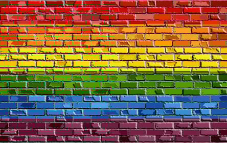 A photo of a brick wall painted to look like a Pride Flag.