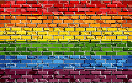 A photo of a brick wall painted to look like a Pride Flag.