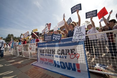 A photo of a group of people gathered for a rally to support healthcare reform.