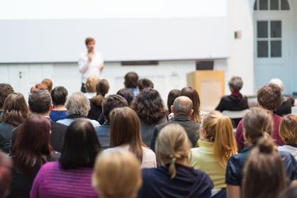 A photo of a woman leading a workplace harassment training seminar.