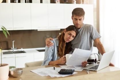 A photo of a worried couple looking over their medical bills.